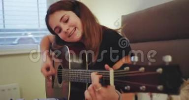一位魅力非凡的少女在卧室里弹吉他，她觉得很享受时光
